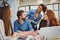 Businessman with happy female coworkers at desk