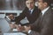 Businessman headshot at meeting in modern office. Entrepreneur sitting at the table with colleagues. Teamwork and