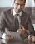 Businessman headshot at meeting in modern office. Entrepreneur sitting at the table with colleagues. Teamwork and