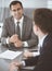 Businessman headshot at meeting in modern office. Entrepreneur sitting at the table with colleagues. Teamwork and