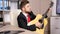 Businessman in his office plays at acoustic guitar