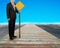 Businessman hold yellow board standing on wooden way