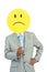 Businessman holding angry smiley face balloon