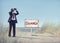 Businessman Holding Binoculars with Signboard on Beach