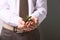 Businessman holding green seedling with soil, closeup