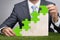 Businessman holding jigsaw graph on grass