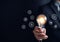Businessman holding lightbulb with learning educate and graduation concept. study knowledge to creative thinking idea and problem