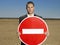 Businessman Holding \'No Entry\' Sign In Desert