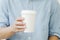 A businessman holding and a paper cup of hot coffee in cafe