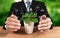 Businessman holding plant symbolize environmental protection. Reliance