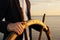 Businessman holding ship rudder and navigates in sunset light