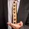 Businessman holding stacked blocks reading Auction