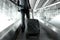 Businessman holding trolley bag going up on airport escalator