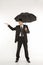 Businessman holding umbrella with hand held out.