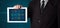 Businessman holding a white modern tablet with blurry apps