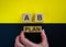 Businessman holds a block with word `plan`. Wooden cubes with letters A and B. Beautiful yellow and black background. Copy space