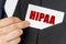 Businessman holds a card with the text - HIPAA