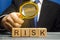 Businessman holds a magnifying glass over the word Risk. Financial and commercial risk concept. Risks assessment and management.
