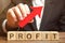 A businessman holds a red arrow up over wooden blocks with the word Profit. Successful business and high profits. Profitability.