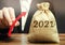Businessman holds an up arrow near the 2021 money bag. Strategy and budget planning. Vision. Business forecasting. Growth and