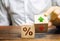 Businessman holds wooden blocks with percent and up or down arrow. Mortgage and loan rates. Interest rate, stocks, ranking.