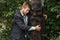 Businessman hugs wooden statue on desert island