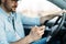 Businessman ignoring safety and texting on mobile phone while driving