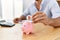 Businessman insert bitcoin in piggy bank at the office