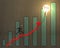 Businessman jumping on growth arrow with bar chart, glowing lamp