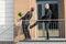 Businessman Kicking Employee With Belongings Outside Office