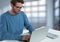 Businessman with laptop at desk with bright background