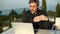 Businessman with laptop morning coffee on balcony at home