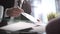 Businessman leafing through documents and signing contract for business deal at work in office closeup