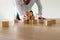 Businessman leaning in to carefully assemble pyramid shape with