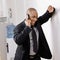 Businessman leaning on wall talking on cell phone