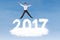 Businessman leaping above cloud shaped number 2017