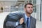 Businessman leaving office with full black plastic bag