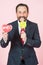 Businessman with lollipop and heart in hands. portrait of funny handsome man holding candy and opened mouth with tongue.