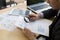 Businessman looking through a magnifying glass to documents