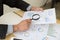 Businessman looking through a magnifying glass to documents