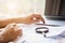 Businessman looking through a magnifying glass to documents. Business assessment and audit. Magnifying glass on a financial report