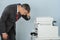 Businessman Looking At Printer Machine At Office