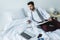 businessman lying on bed with documents, laptop