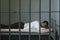 Businessman Lying On Bed In Prison Cell