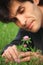 Businessman lying looks at clover flower