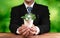 Businessman nurturing and holding plant with recycle symbol. Reliance