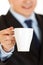 Businessman offering cup of coffee. Closeup.
