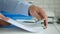 Businessman in Office Archiving Documents with a Paper Hole Puncher