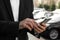 Businessman ordering taxi with smartphone on street, closeup