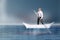 Businessman Paddling on Boat of Paper